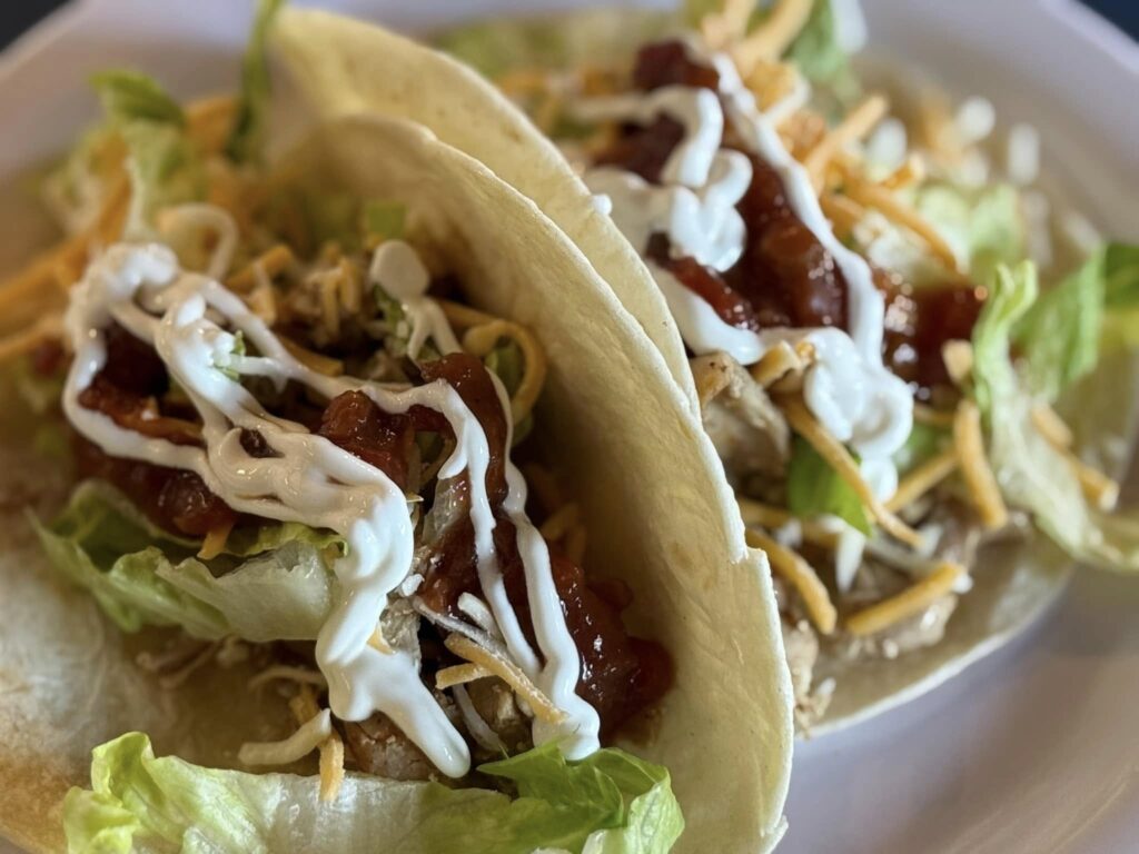 Two tacos with toppings and lettuce