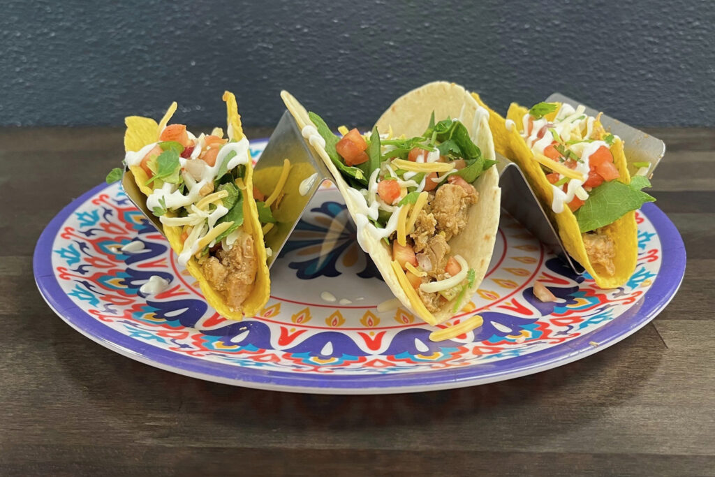 Three tacos on a decorative plate