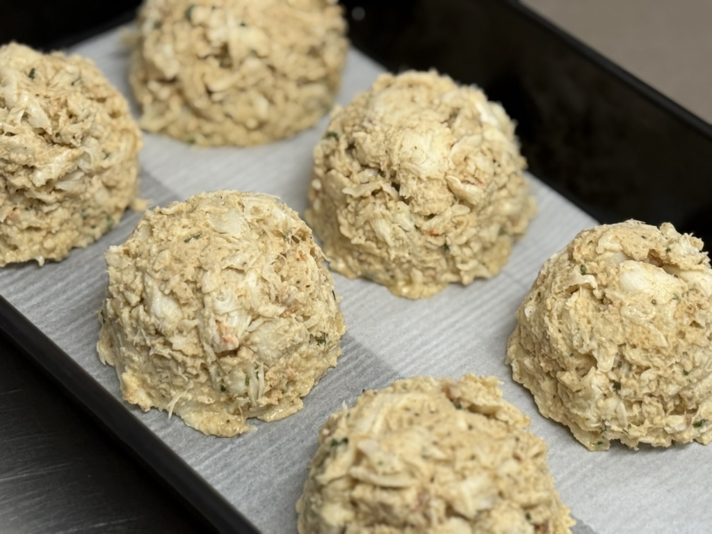 Six crab cake portions on tray