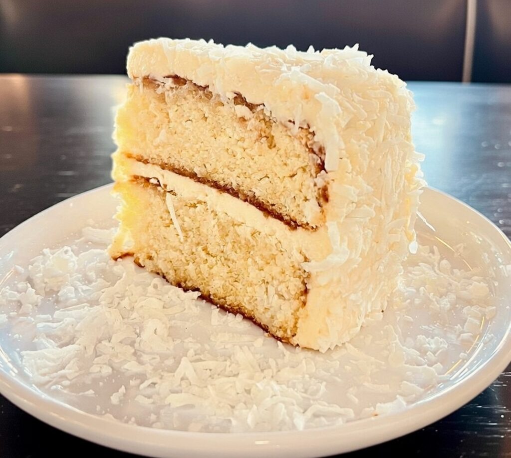 Layered coconut cake on white plate
